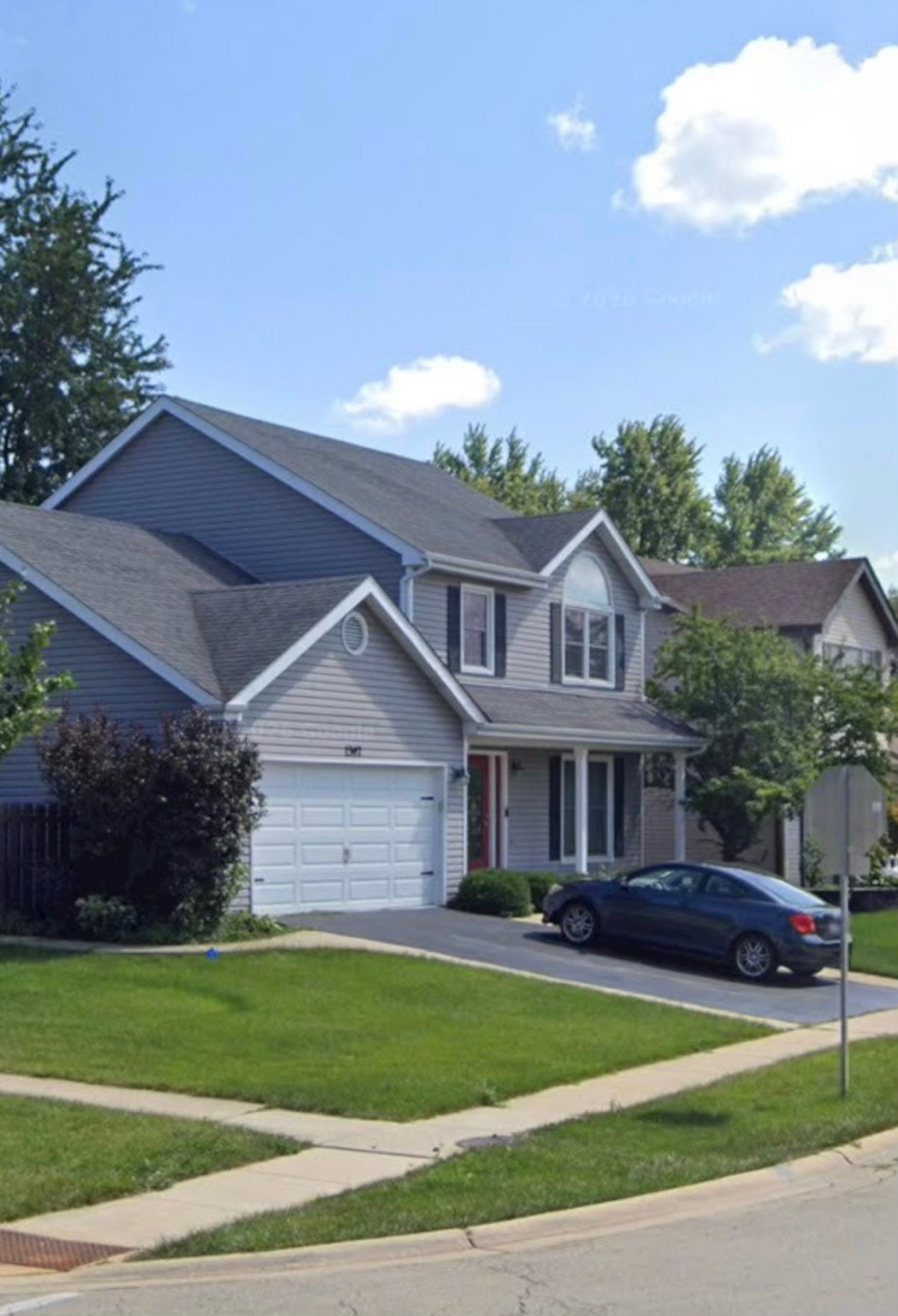 A gray two-story house with an attached garage.