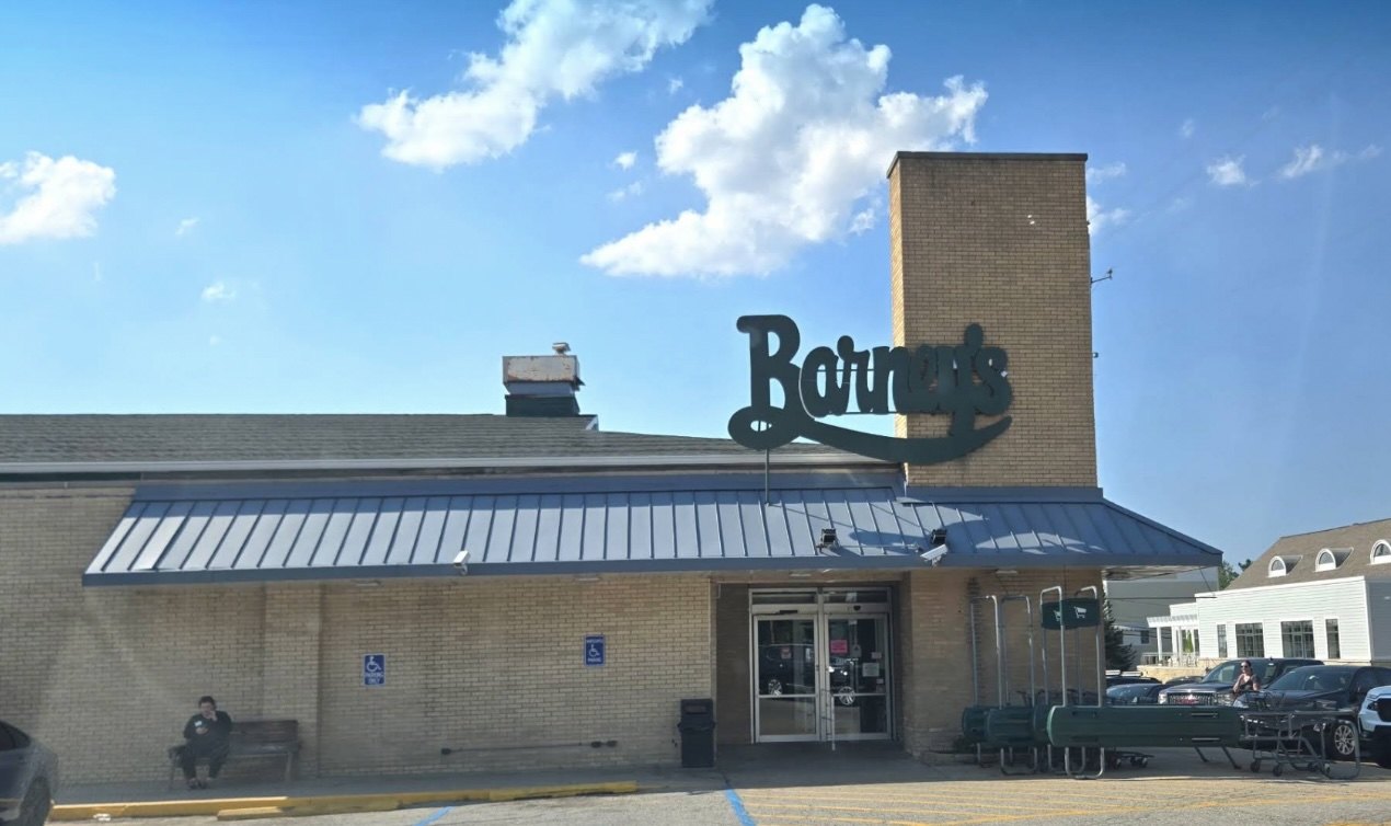 Barney's Market in New Buffalo, tan brick with green awnings and a row of green carts by the door.